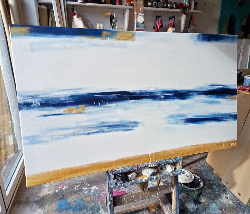 Großes Leinwandbild abstrakt – modernes Gemälde Meer in Blau und Weiß mit Goldakzenten im Atelier